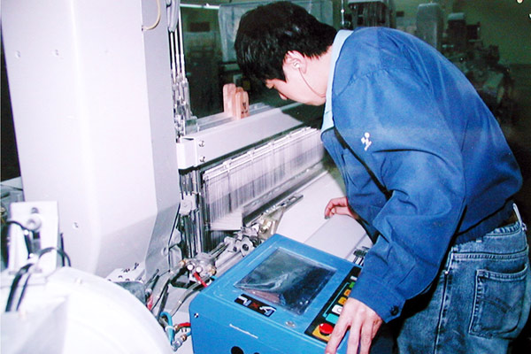 公司技工正在對布機進行調試